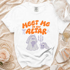 White t-shirt with orange text "Meet me at the altar" and a bridal ghost graphic.