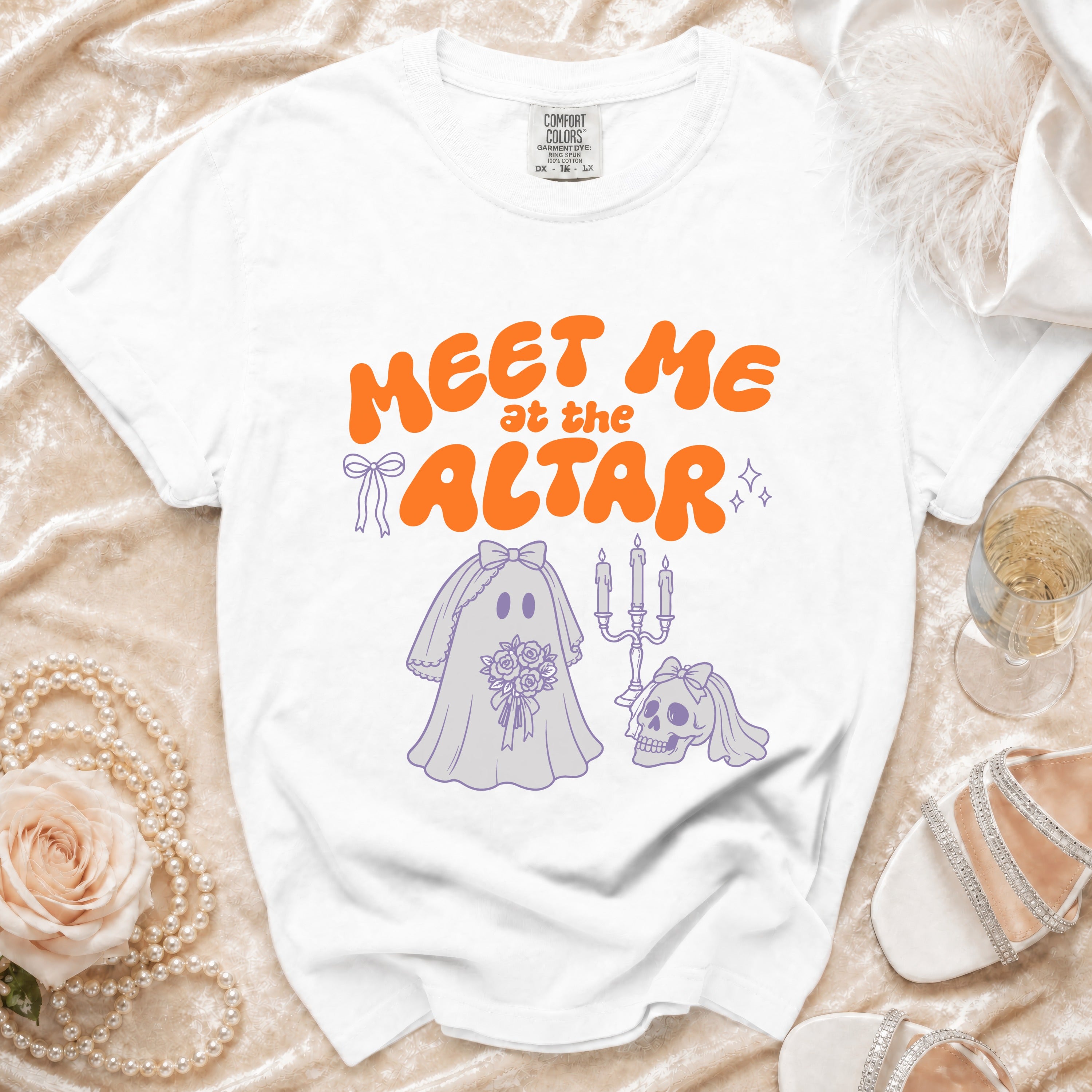 White t-shirt with orange text "Meet me at the altar" and a bridal ghost graphic.