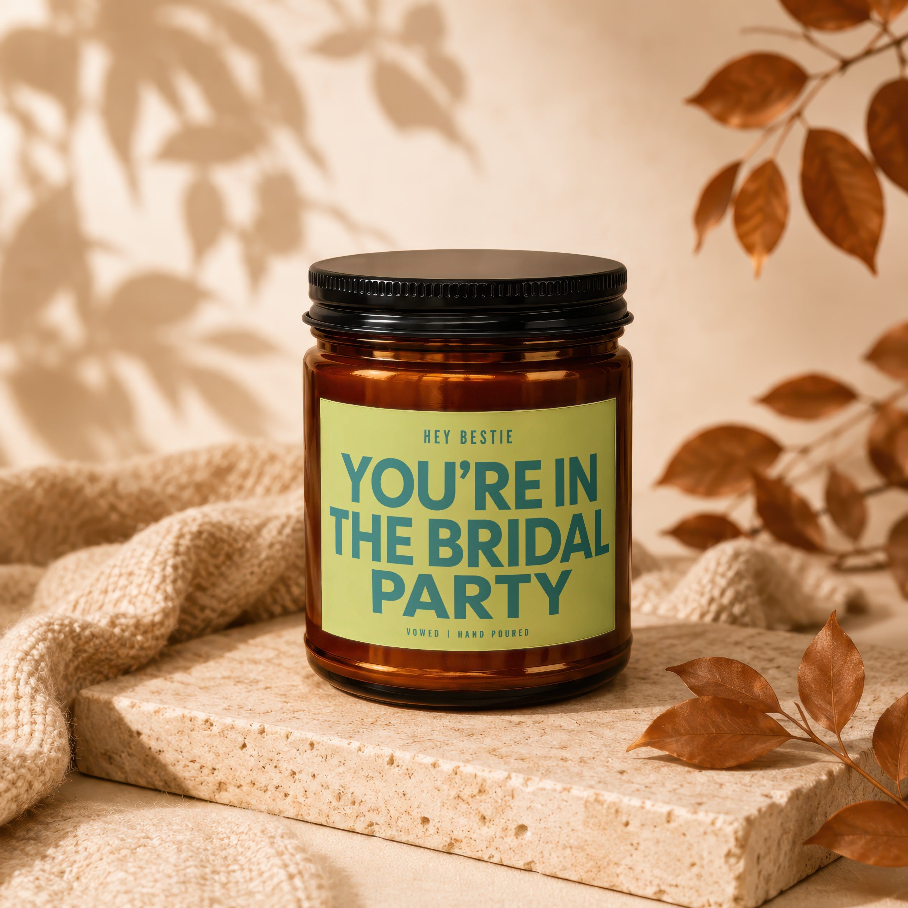 Amber candle with black lid and green label reading "YOU'RE IN THE BRIDAL PARTY".