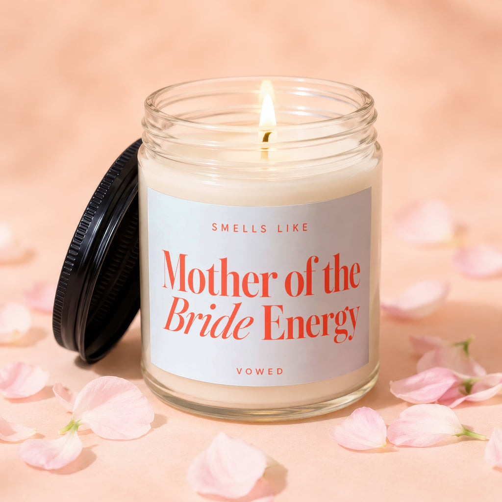 Glass jar candle with lit wick reads "Smells Like Mother of the Bride Energy".