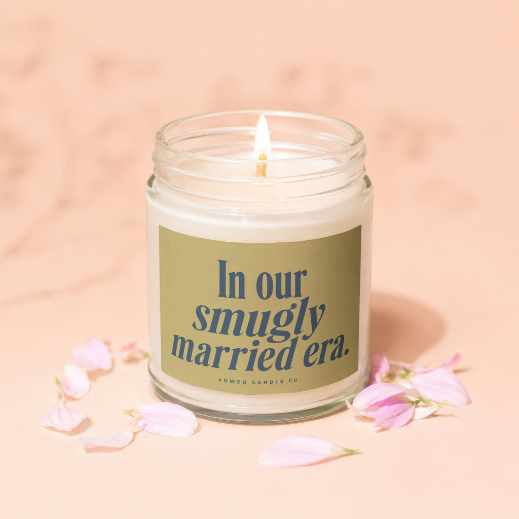 Lit candle in jar with label reading "In our smugly married era."