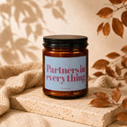 Brown candle with black lid and "Partners in everything" text label.