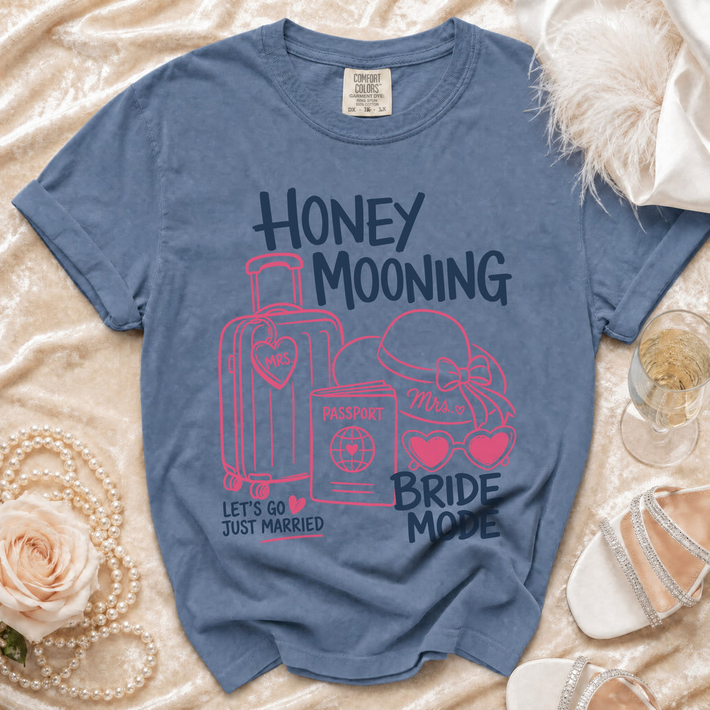 Blue t-shirt with "Honey Mooning Bride Mode" graphics, suitcase, passport, and hat.