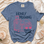 Blue t-shirt with "Honey Mooning Bride Mode" graphics, suitcase, passport, and hat.