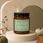 Amber candle with "Joyfully Engaged, vowed" text on a light blue label.