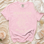 Pink t-shirt with "Reckless in Texas" and cowboy boots graphic.