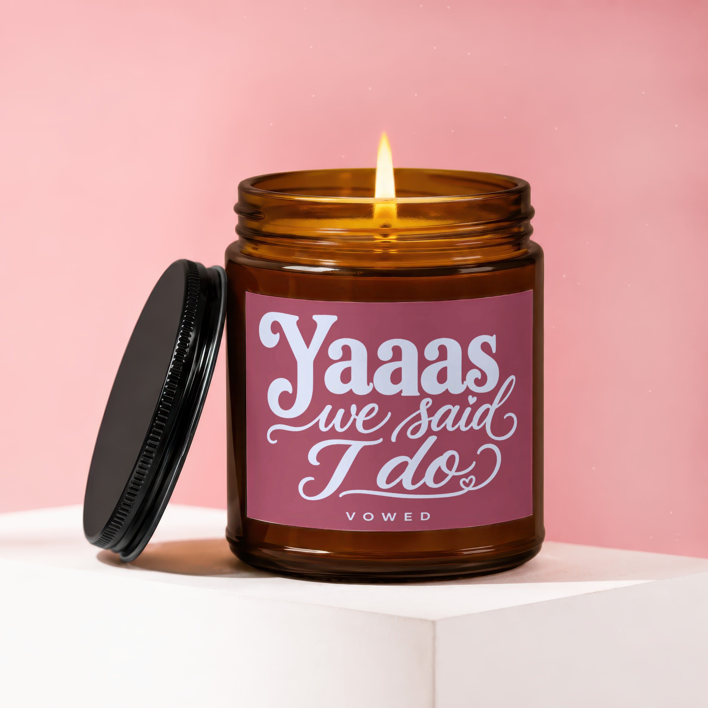 Amber jar candle with lit flame and "Yaaas we said I do VOWED" text.