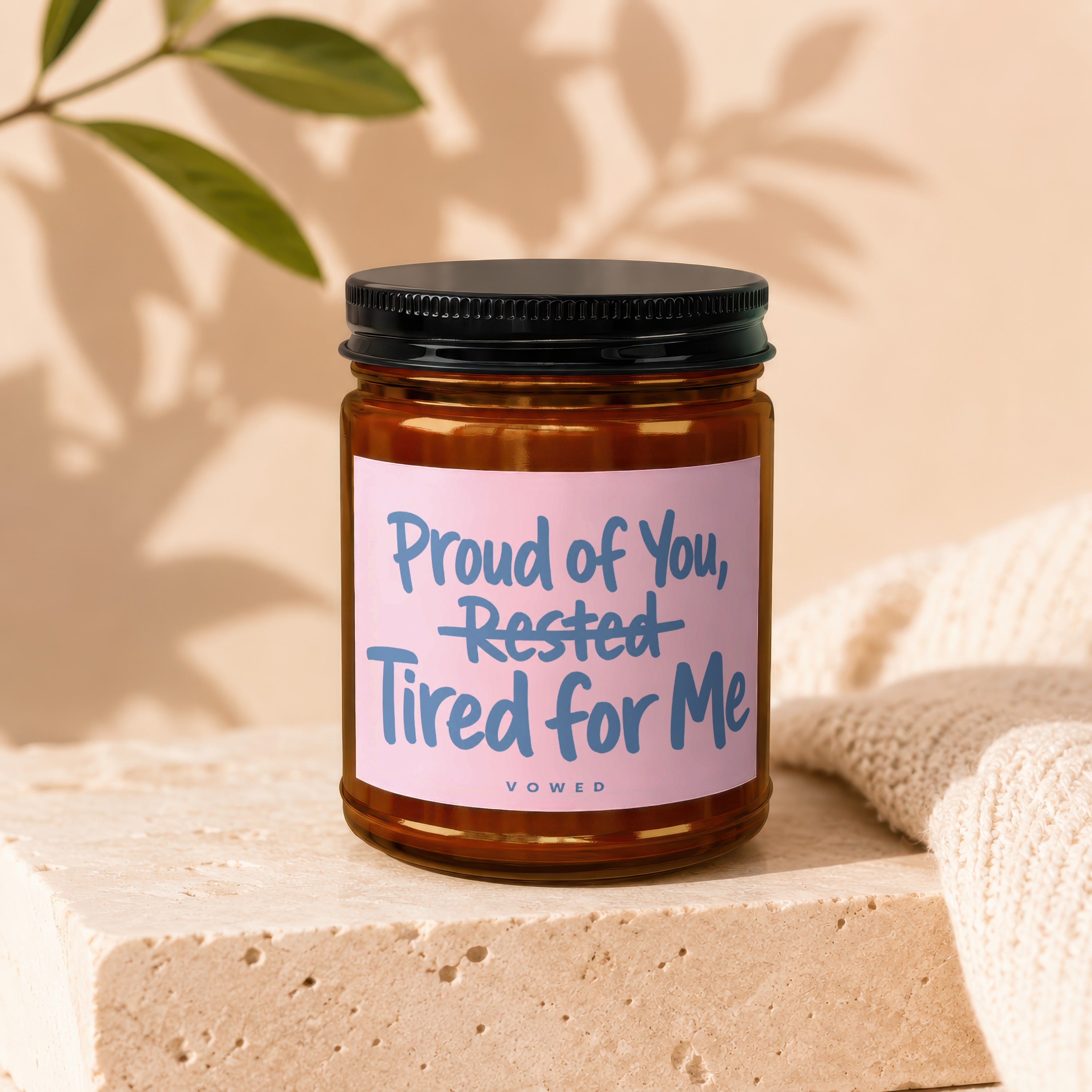 Candle with pink label reading "Proud of You, Rested Tired for Me"