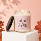 Glass candle with "Future Mrs." text on pink label, lit flame.