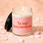 Glass candle with pink label reading "In my honeymoon era."