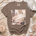Brown crewneck t-shirt featuring a pastel Halloween illustration of a ghost in a bathtub, surrounded by pumpkins, candles, and flowers, with text reading I DO CREW.