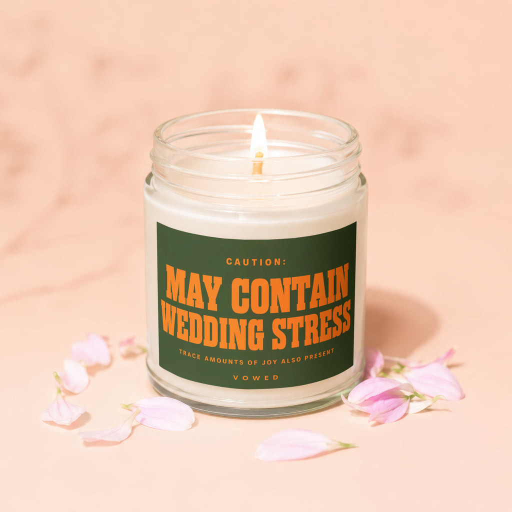 Candle labeled "May Contain Wedding Stress" with flower petals.