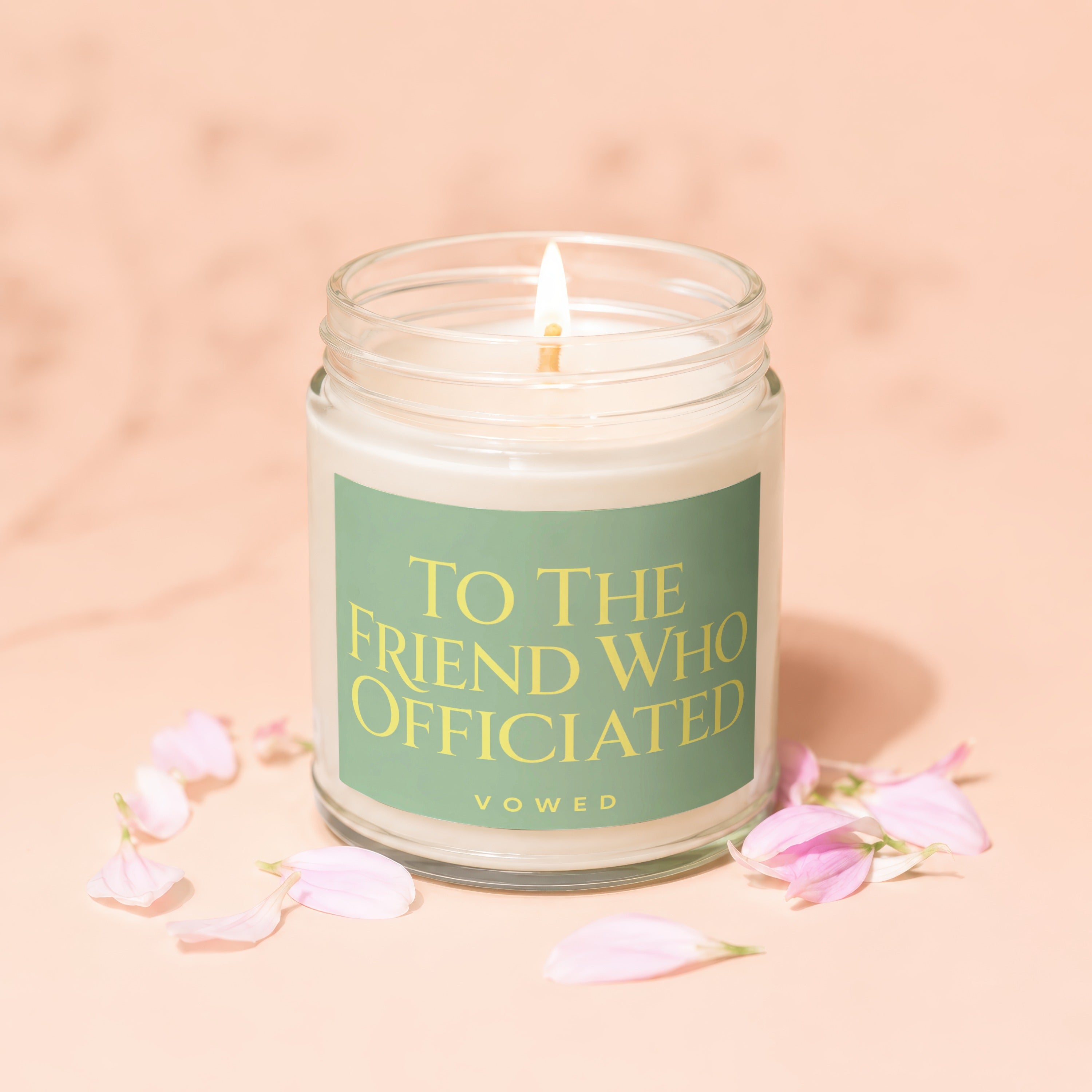 Glass candle with lit wick, reads "To The Friend Who Officiated Vowed".