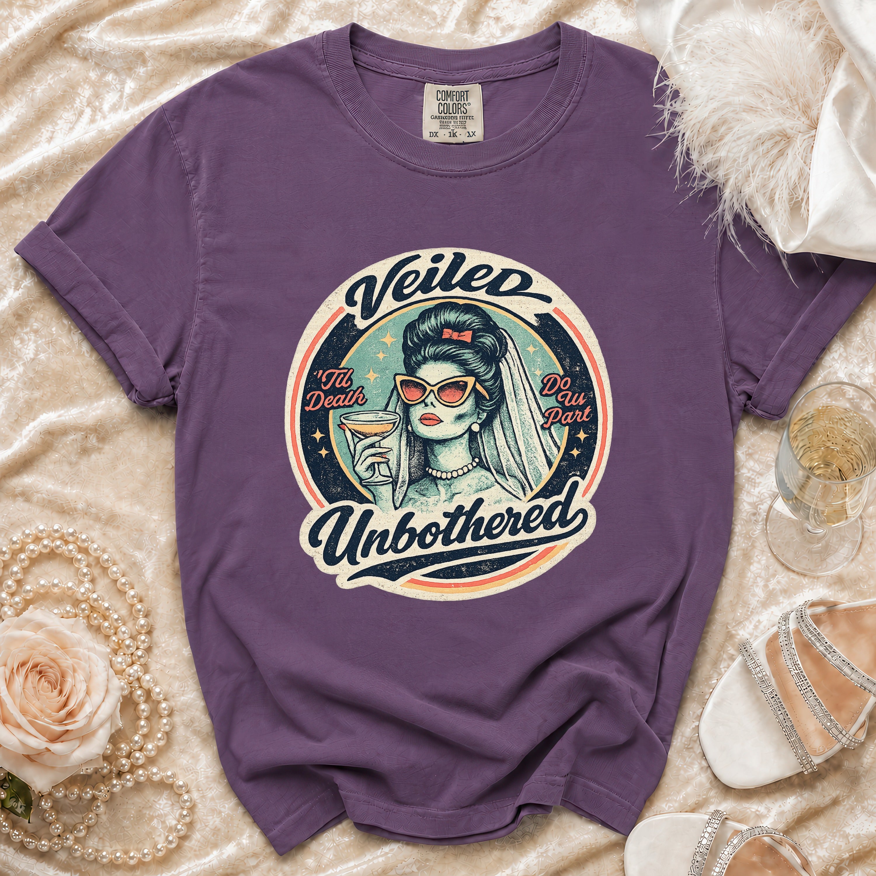 Purple t-shirt with a graphic of a bride saying "Veiled 'Til Death Do Us Part Unbothered".