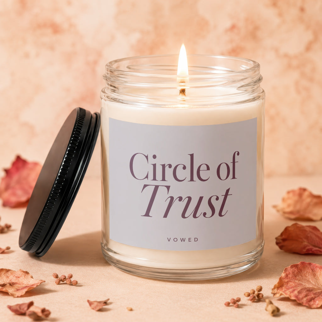 Glass jar candle with white wax, lit wick, and "Circle of Trust" label.