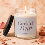 Glass jar candle with white wax, lit wick, and "Circle of Trust" label.