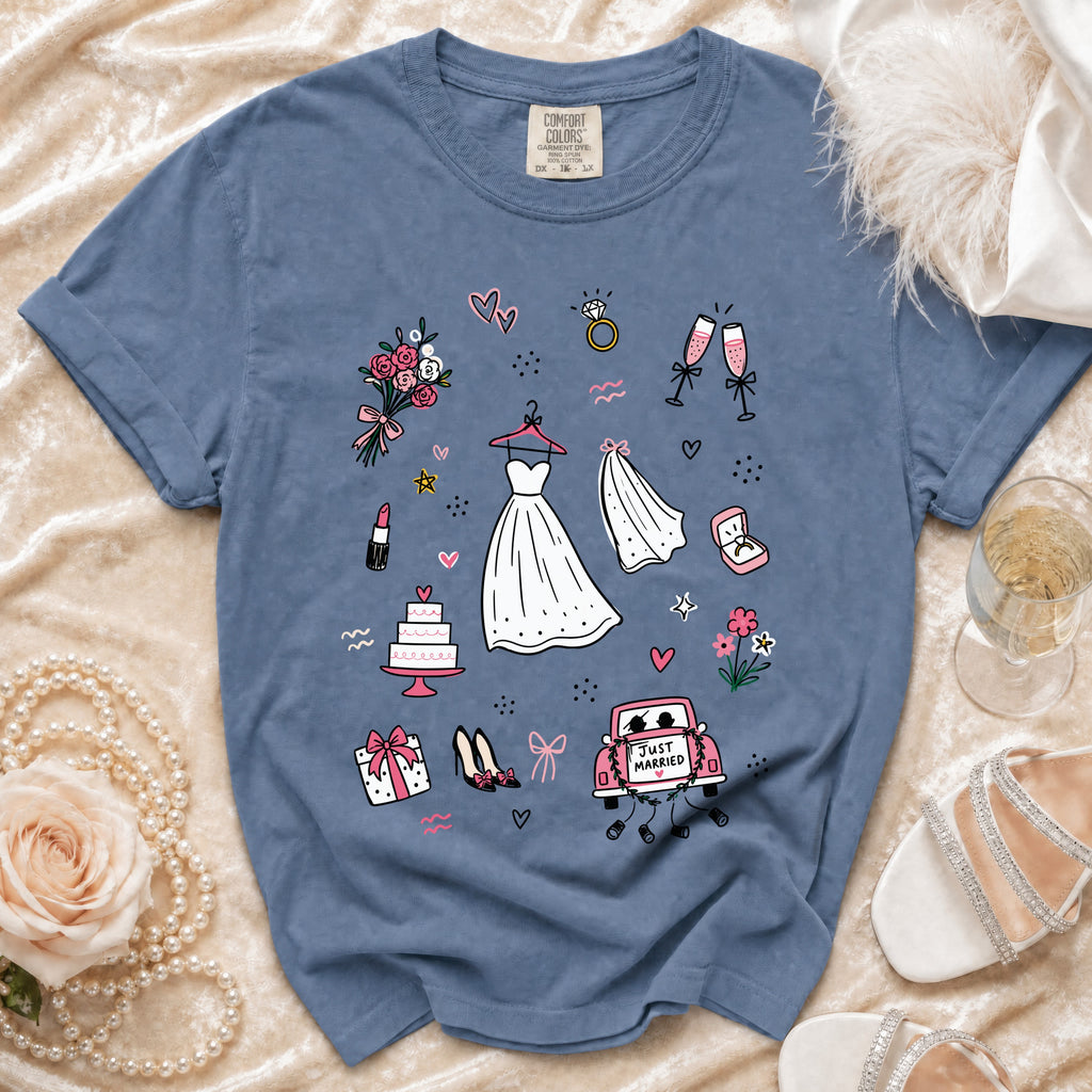 Blue t-shirt with wedding-themed illustrations: dress, rings, cake, flowers, and car.
