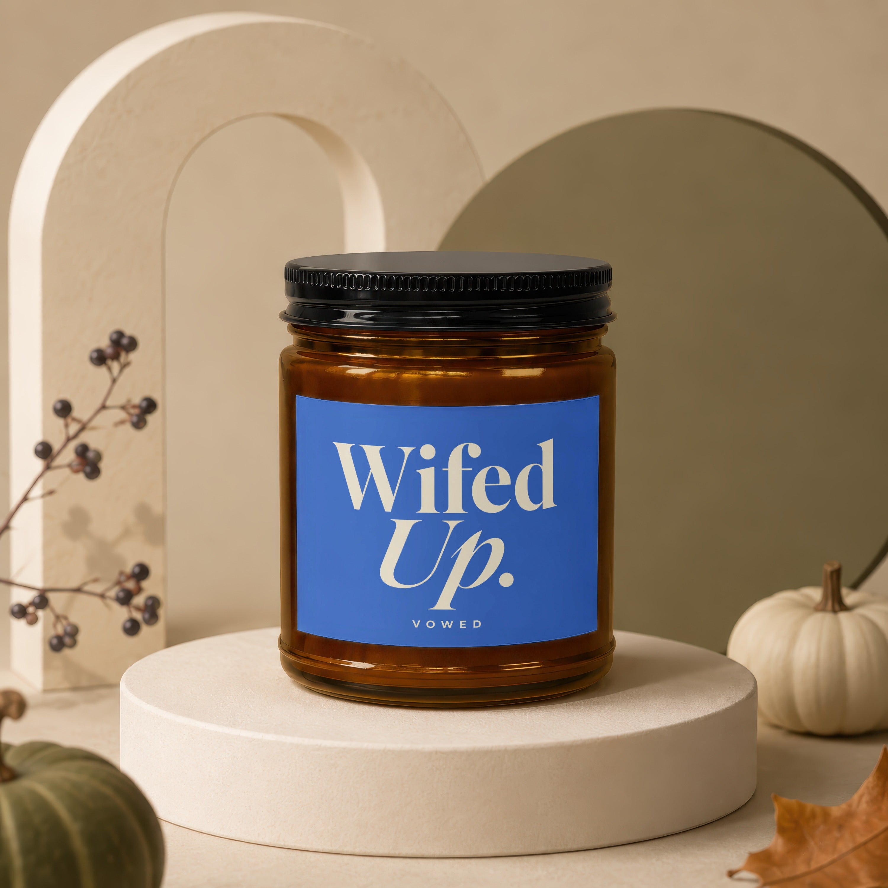 Amber jar candle, "Wifed Up." text on blue label, with pumpkins and autumn decor.