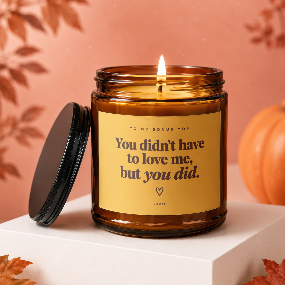 Amber candle with lit wick and lid nearby, reads "You didn't have to love me, but you did."
