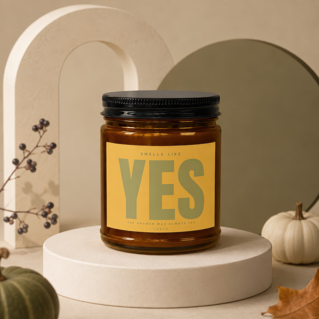 Amber jar candle with "YES" and "The Answer Was Always Yes" text on yellow label.
