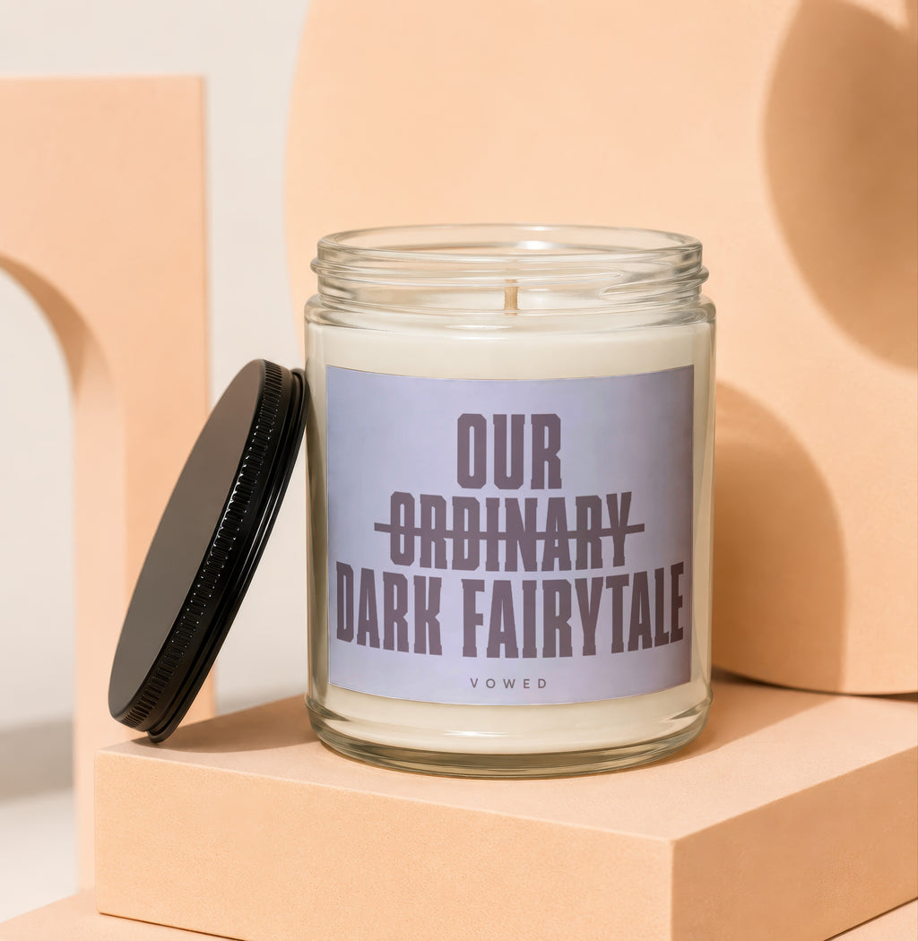 Glass candle with black lid removed, label reads "Our Ordinary Dark Fairytale".