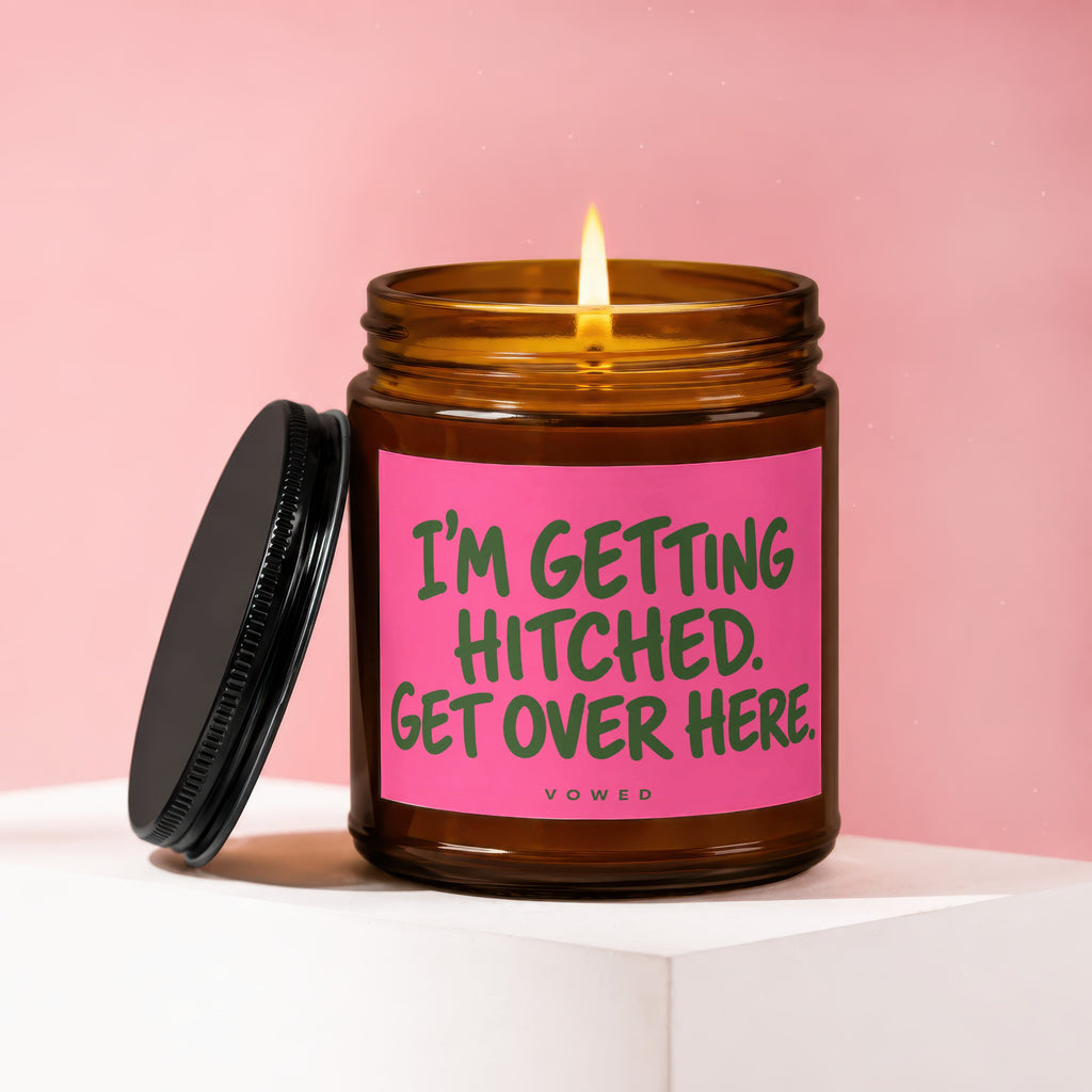 Amber jar candle with a pink label reading "I'M GETTING HITCHED. GET OVER HERE."