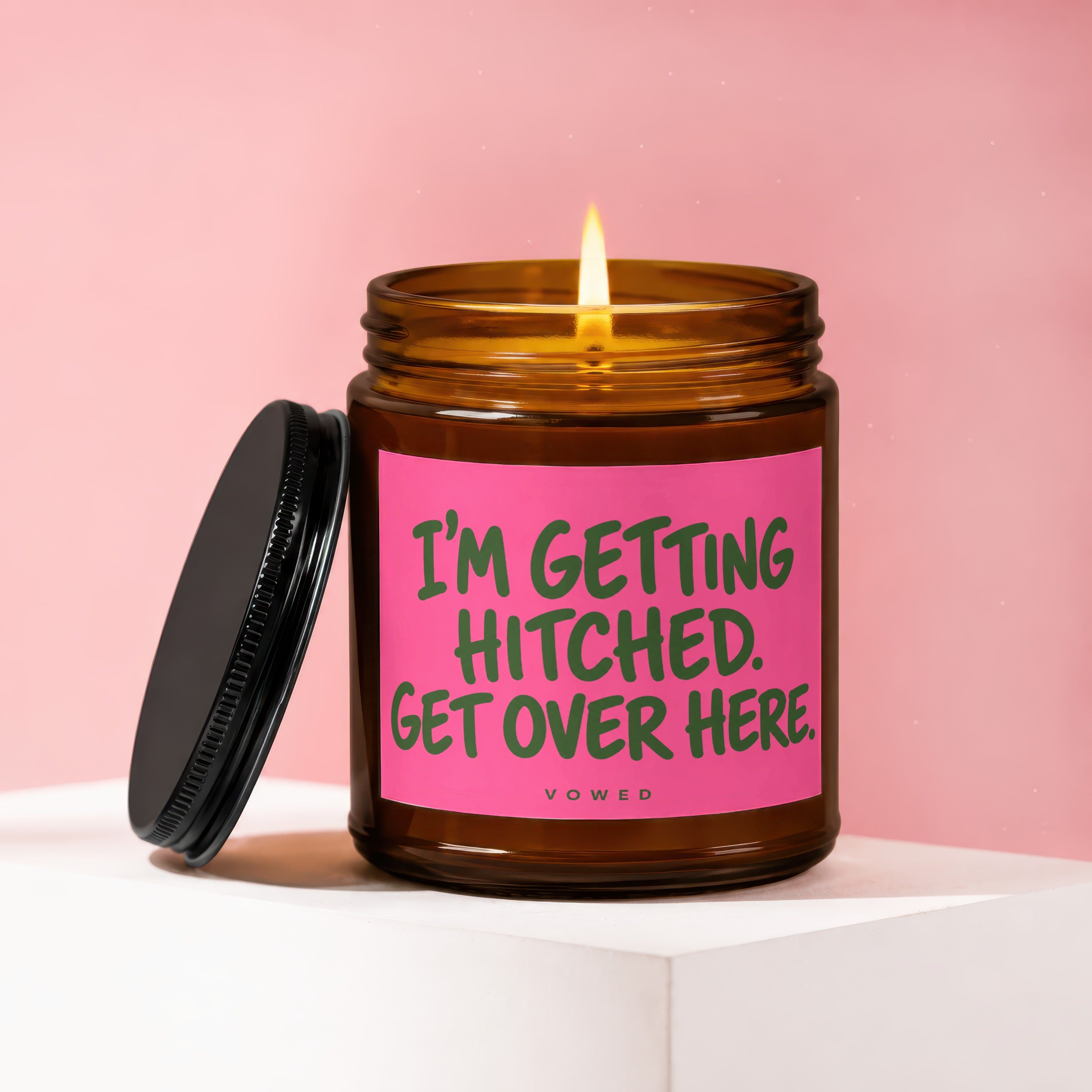 Amber jar candle with a pink label reading "I'M GETTING HITCHED. GET OVER HERE."