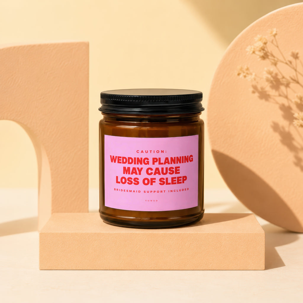 Amber jar candle with pink label reading "Wedding planning may cause loss of sleep".