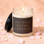 Glass candle with black lid, labeled "The Spark Before Forever".