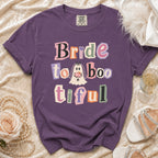 Purple t-shirt with "Bride to Boo-tiful" text and ghost graphic.