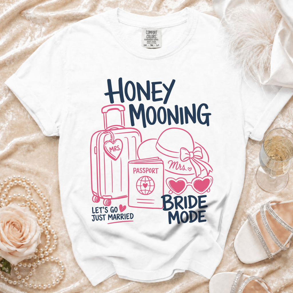 White t-shirt with "Honey Mooning Bride Mode" text and travel icons.