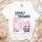 White t-shirt with "Honey Mooning Bride Mode" text and travel icons.