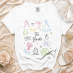 White t-shirt with colorful line drawings of wedding elements and text "The Bride".