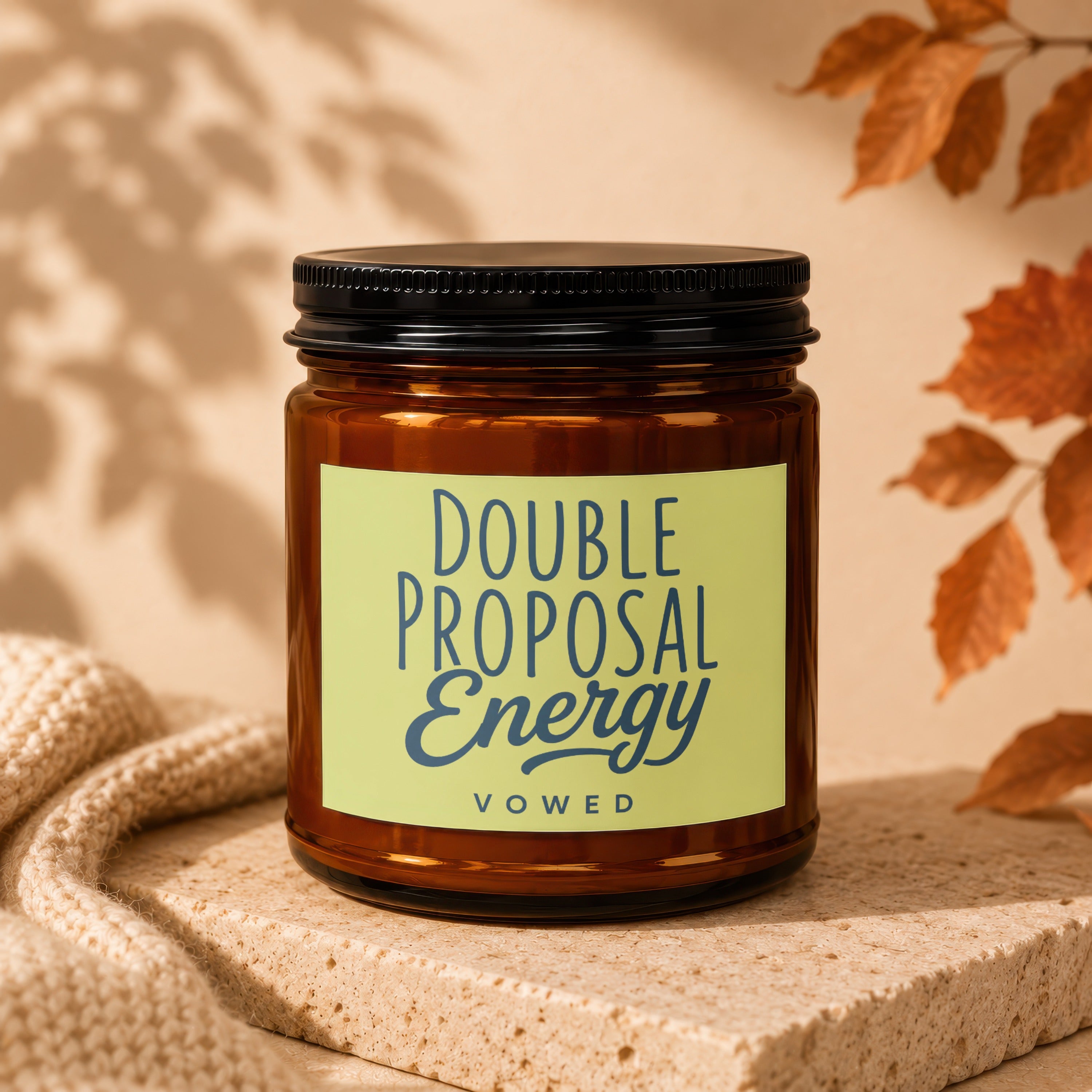 Amber jar candle with "DOUBLE PROPOSAL Energy vOWED" on a light green label.
