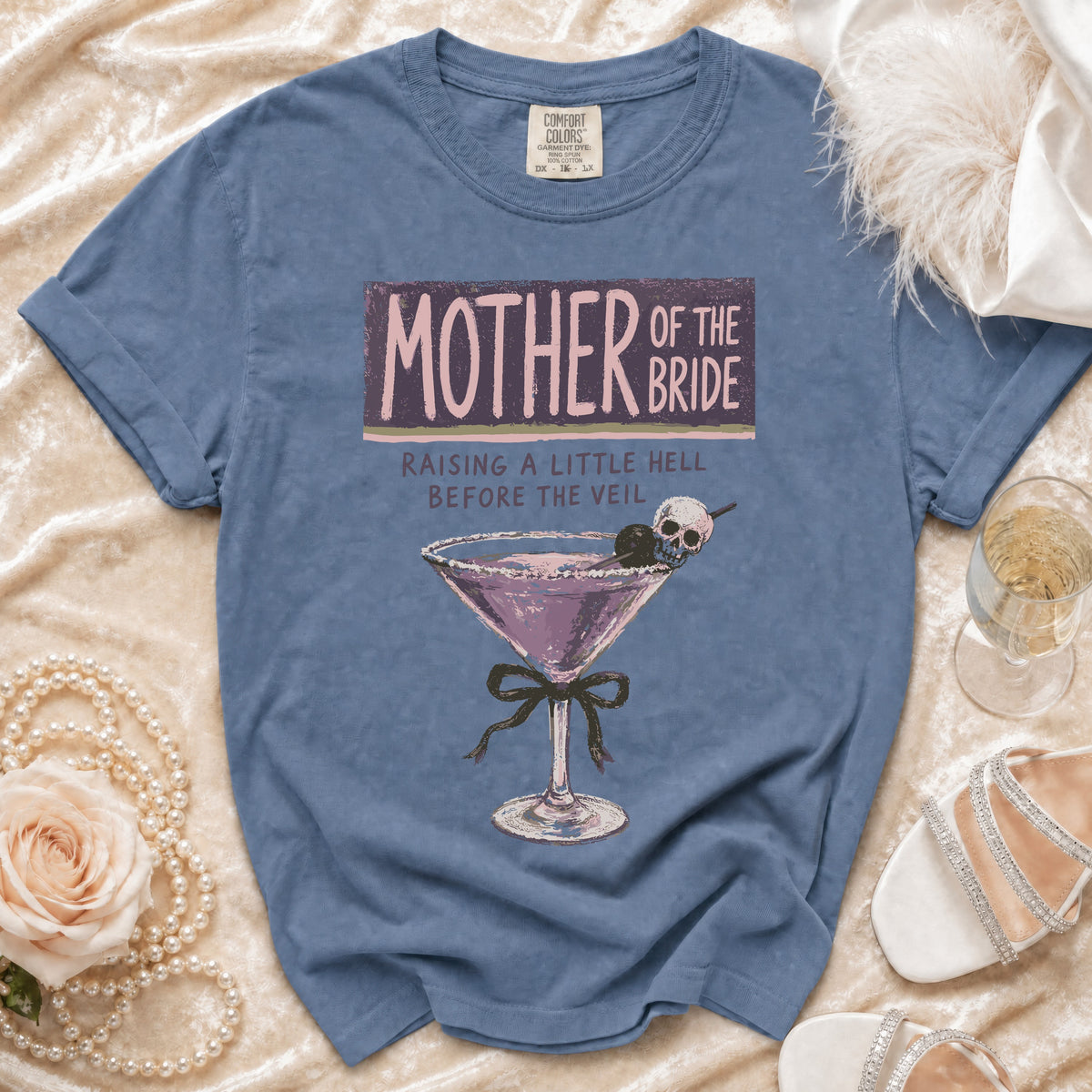 Blue t-shirt with "Mother of the Bride" graphic and cocktail.