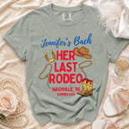 "Jennifer's Bach" and "Her Last Rodeo" text on a grey t-shirt with cowboy boots and hat.