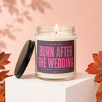 Candle with pink text saying "BURN AFTER THE WEDDING" on a dark label.