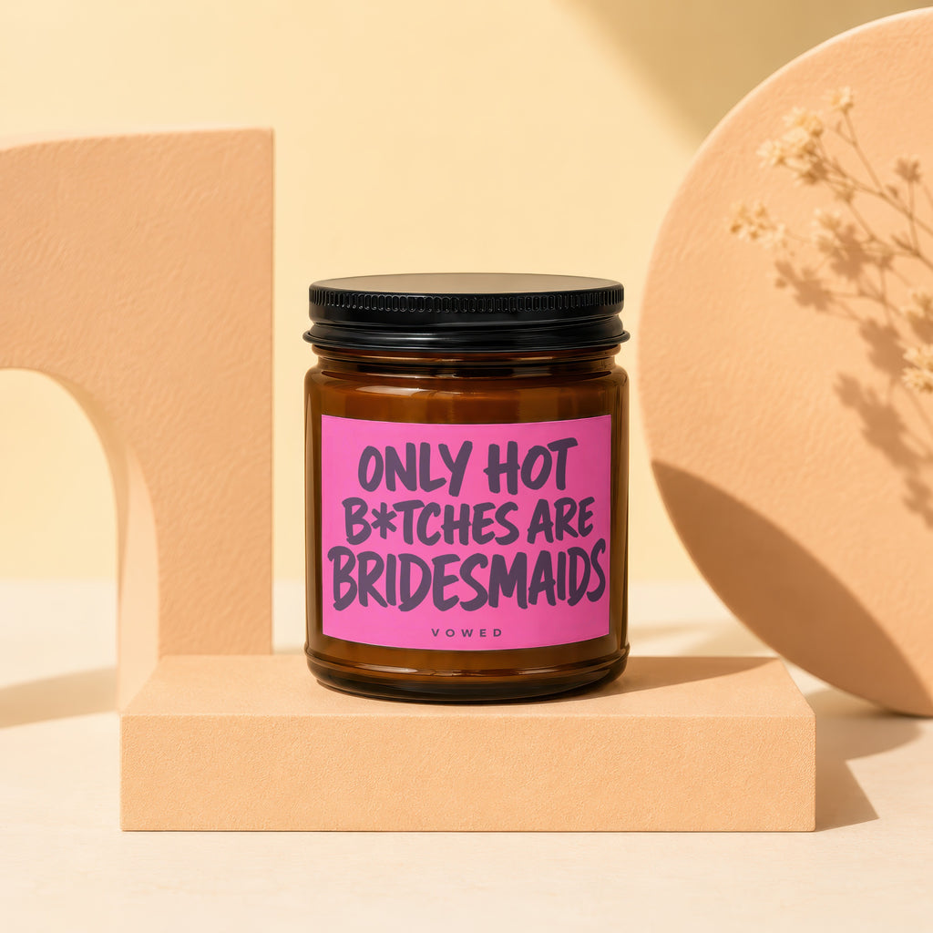Amber candle with black lid and pink label reading "Only Hot B*tches Are Bridesmaids".
