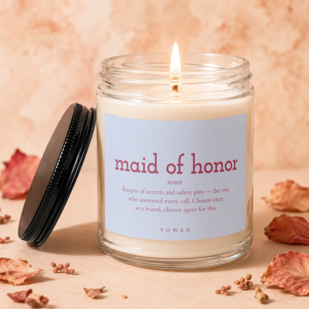 Lit "Maid of Honor" candle with definition text and a black lid.