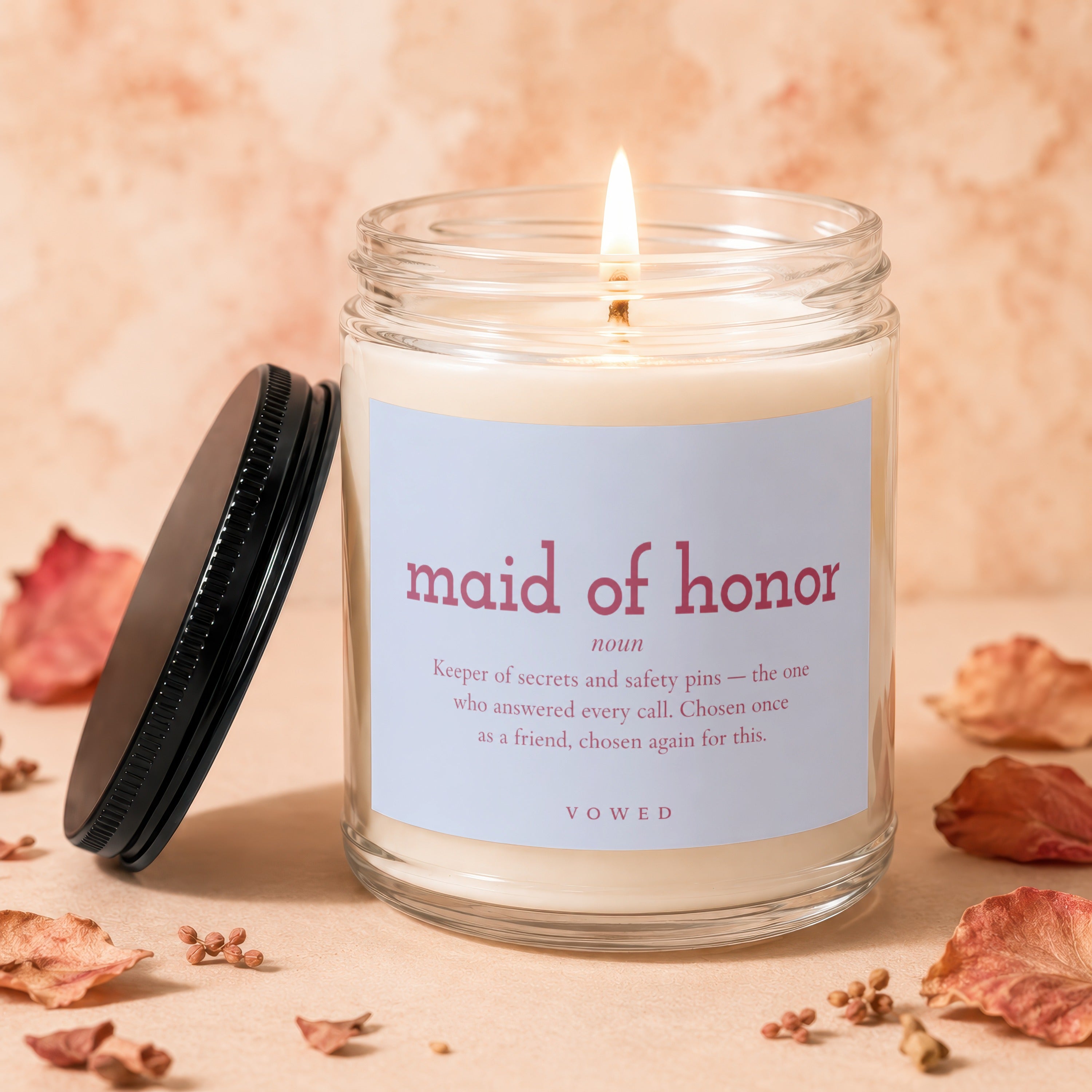 Lit "Maid of Honor" candle with definition text and a black lid.