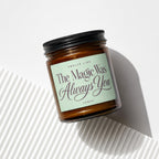 Amber glass candle with black lid, label reads "Smells Like The Magic Was Always You".