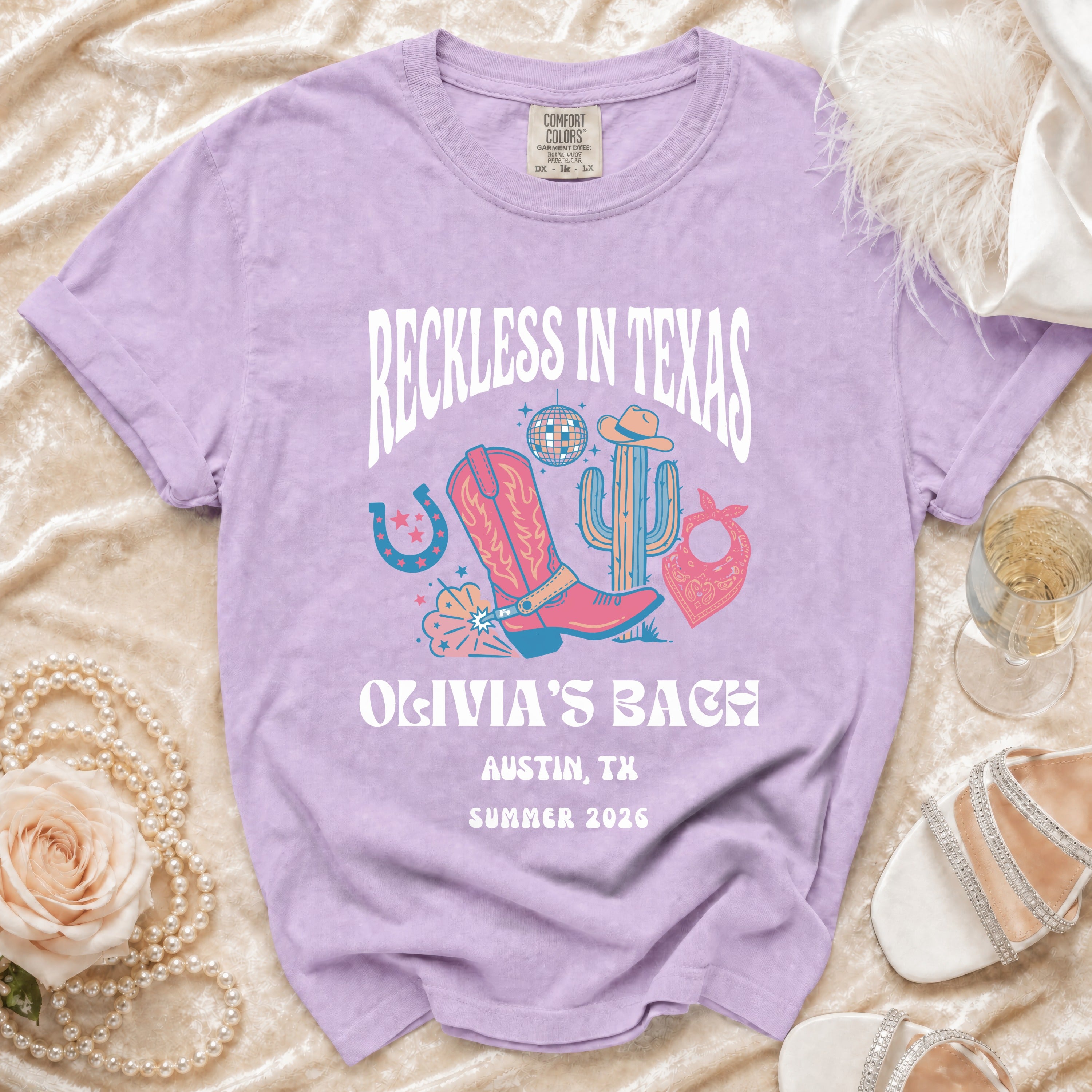 Purple t-shirt with "Reckless in Texas Olivia's Bach Austin, TX Summer 2026" graphic.