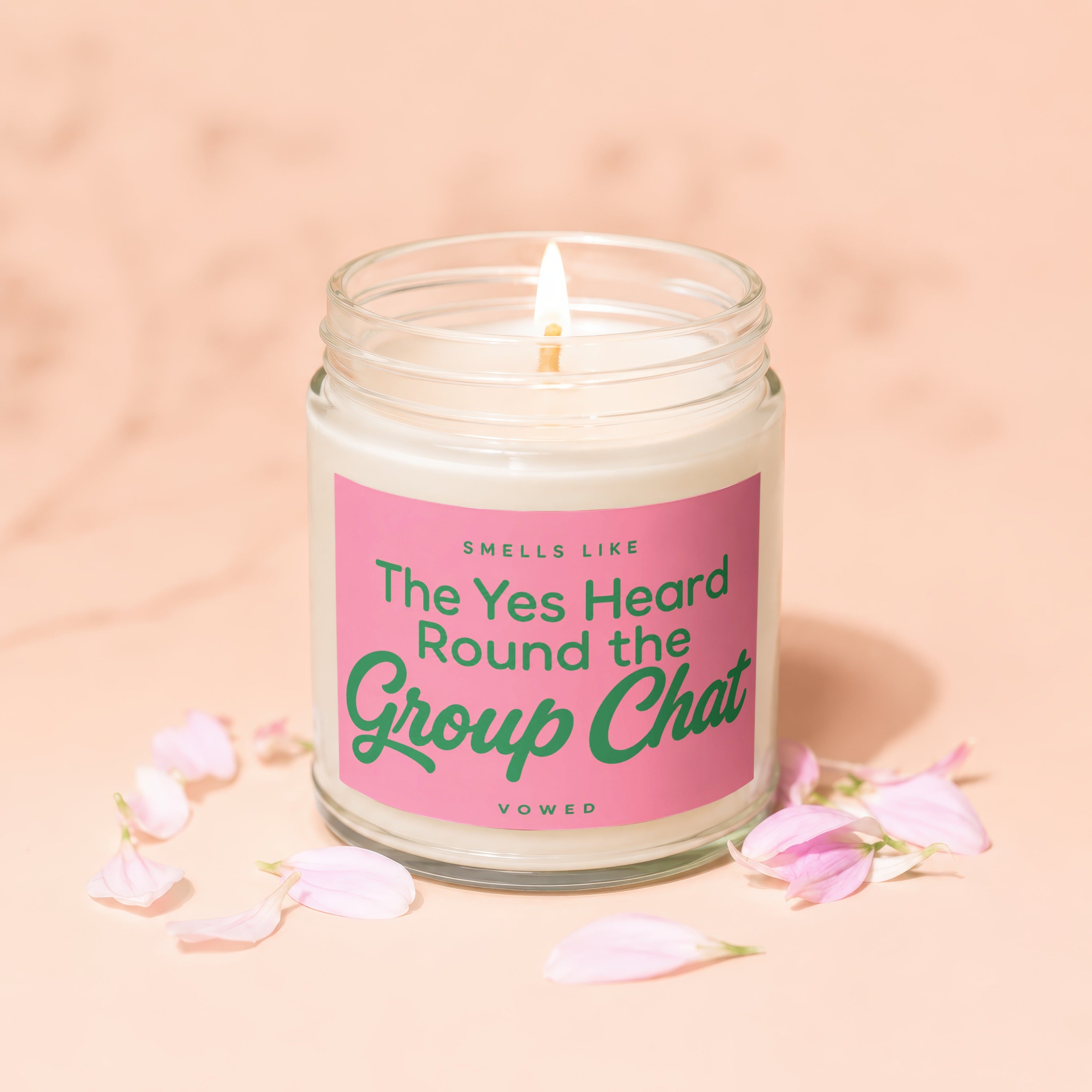 Candle with pink label saying "Smells like The Yes Heard Round the Group Chat Vowed"
