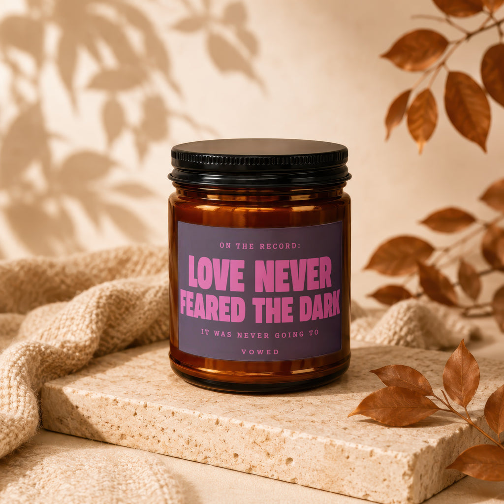 Amber jar candle with "Love Never Feared the Dark" on label.