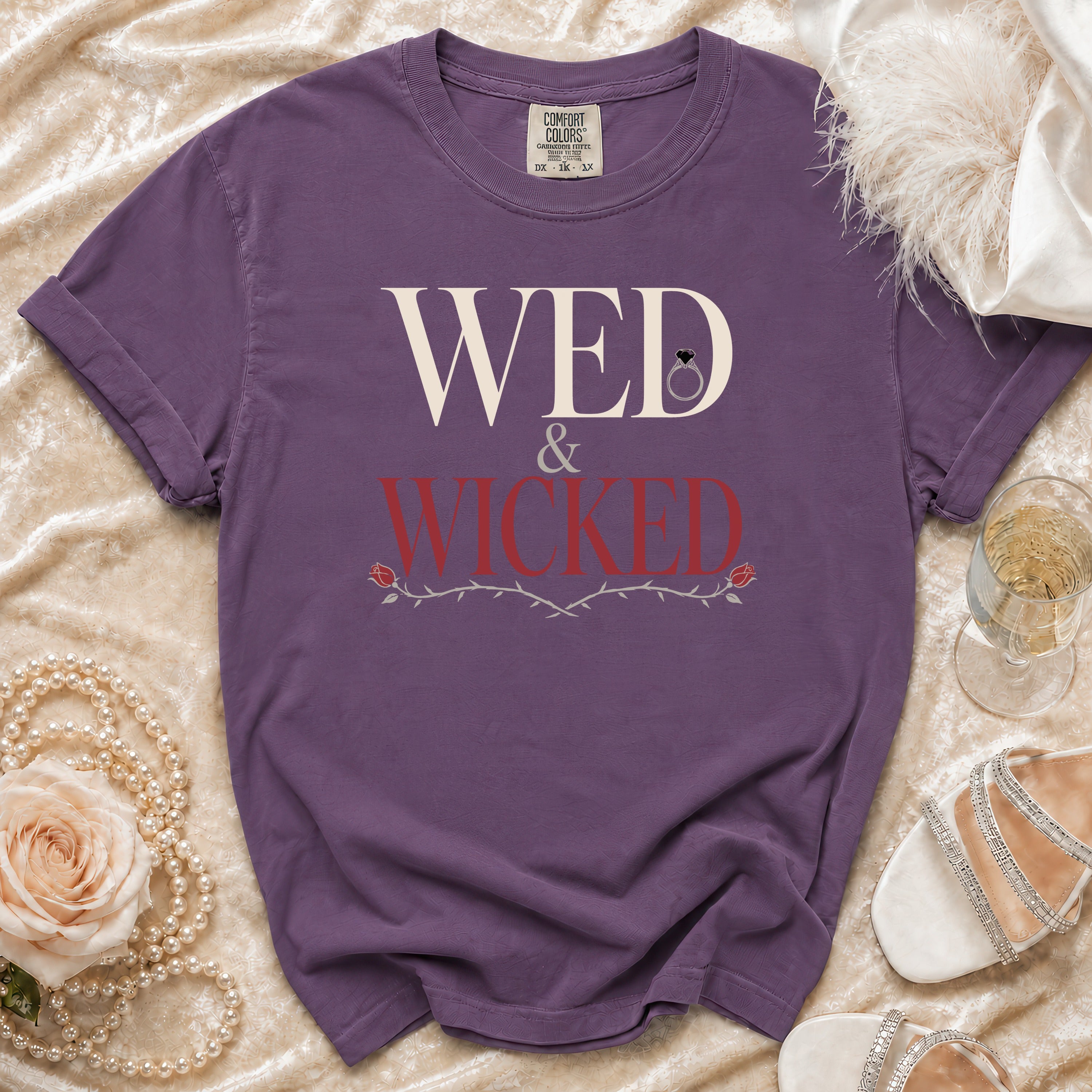 Purple t-shirt with "WED & WICKED" text and a diamond ring graphic.