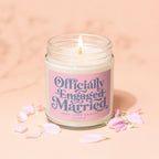 Candle with "Officially Engaged Married" text and pink petals scattered around.