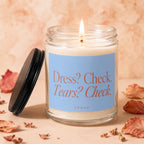 Candle with label "Dress? Check. Tears? Check. VOWED." with lid off.