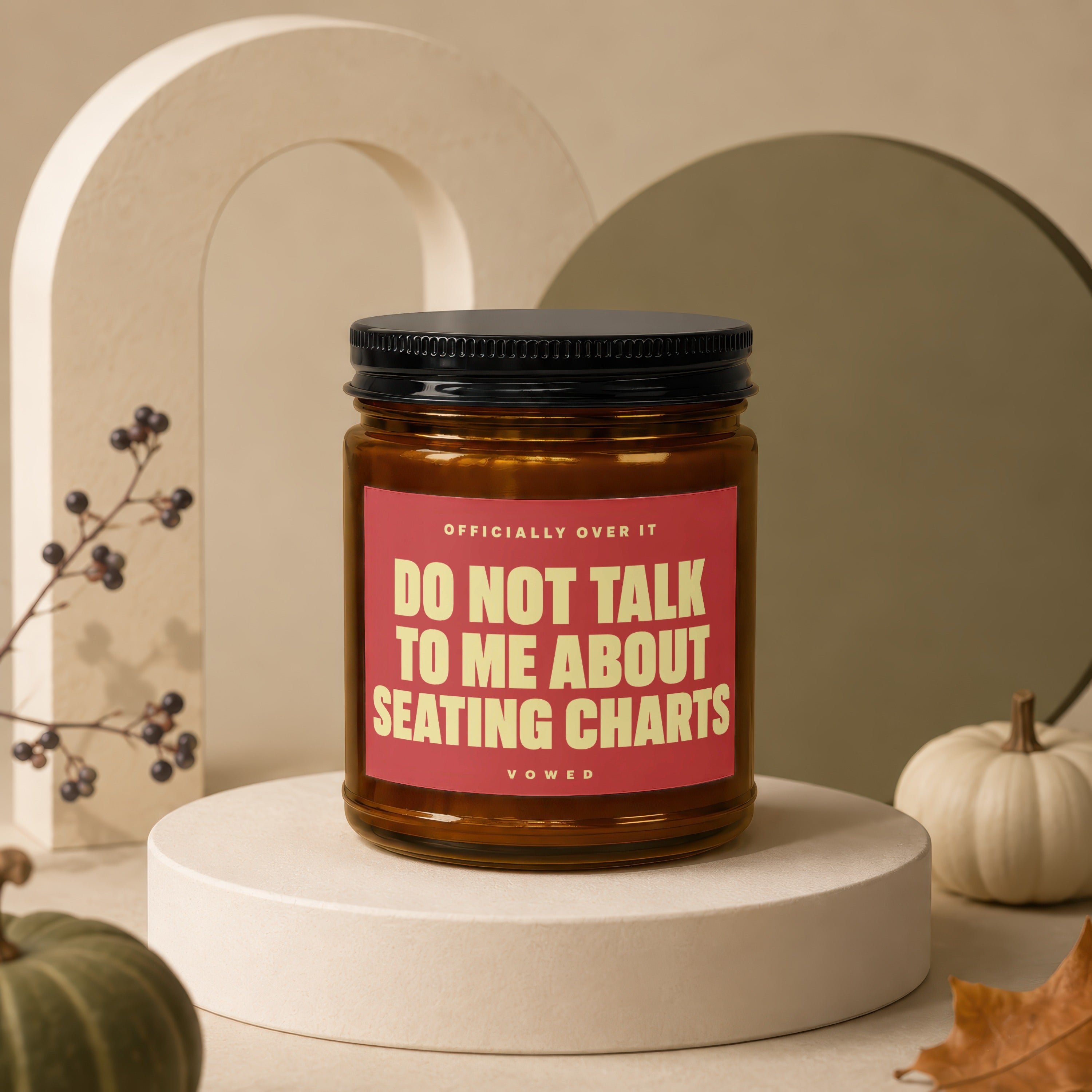 Amber candle with red label reading "Do Not Talk To Me About Seating Charts".