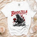White t-shirt with "Bridezilla" text and Godzilla in a wedding veil holding flowers.