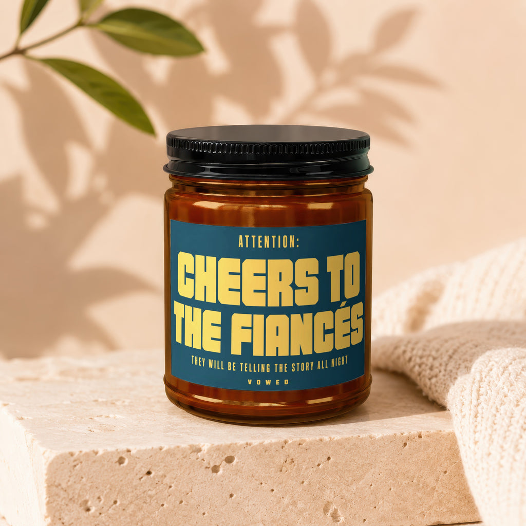 Candle with text "Cheers to the Fiances. They will be telling the story all night."